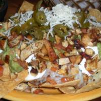 29. Supreme Nachos · Chips topped with melted cheese, refried beans, guacamole, sour cream, pico de gallo, jalape...
