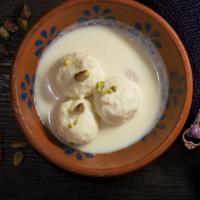 Ras Malai · Flattened balls of malai clotted cream flavored with cardamom soaked in a sweetened cream.