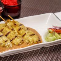 Chicken Satay · Grilled marinated chicken skewers served with homemade peanut sauce and cucumber salad.