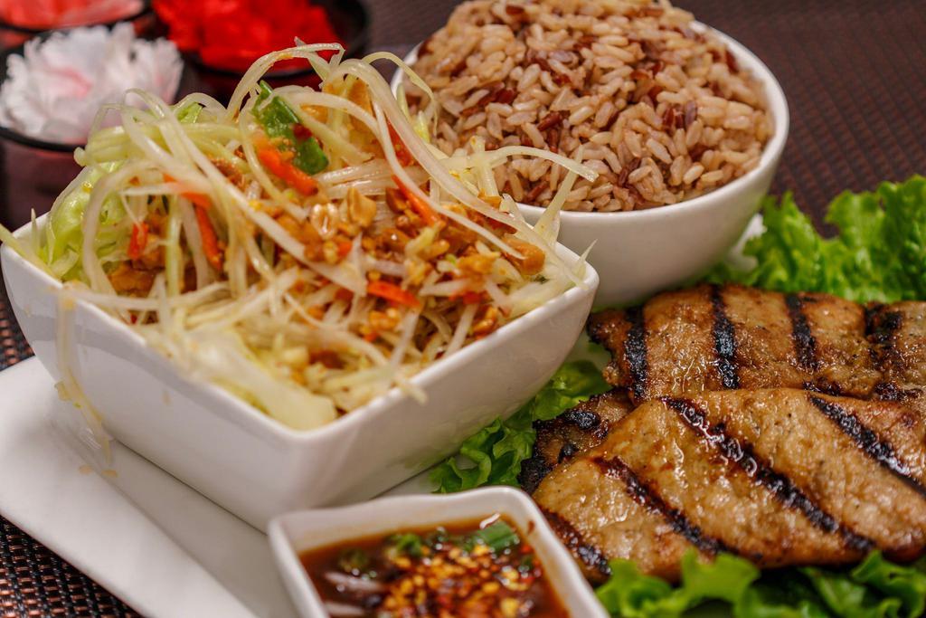 Grilled Pork (Moo Yang) · Thai style BBQ pork with papaya salad or mix salad, sticky rice or steamed rice and served with spicy sauce.