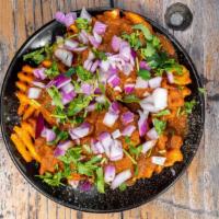 Curry Fries · Masala seasoned waffle fries topped with spicy curry sauce, red onions and fresh cilantro.