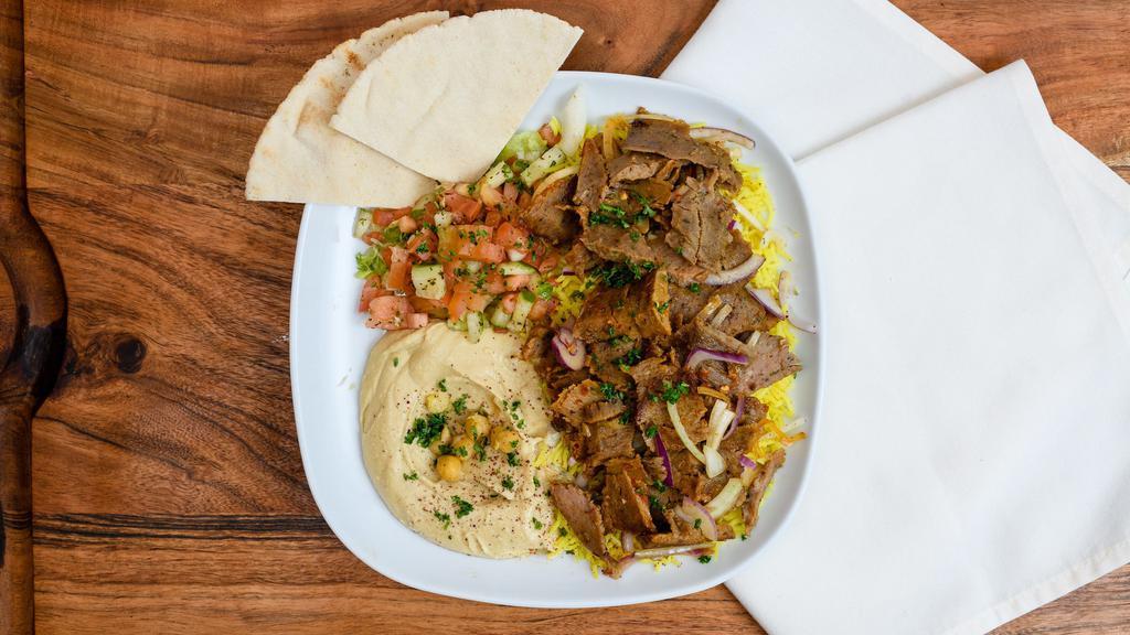 Lamb and Beef Shawarma Combo · Stir-fried shredded lamb and beef marinated in a Mediterranean blend of herbs and spices served with yellow rice and mixed vegetables.