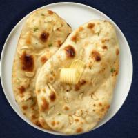 Grab A Garlic Naan · Freshly baked bread in a clay oven garnished with garlic and butter