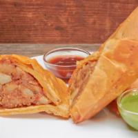 Samosa · potatoes, peas and spices filled in a triangular pastry served with tamarind and cilantro ch...