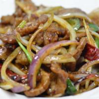 Mongolian Beef 蒙古牛 · Tender beef slices stir-fried with white onions, chili pepper jalapeño in brown sauce. Spicy.