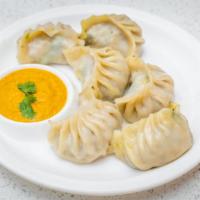 Everest Chicken Momo · Nepali delicacy prepared with shredded ground chicken and Himalayan spices filled in cover w...