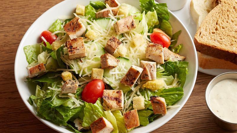 Chicken Caesar | Caesar · Grilled chicken breast, garden fresh romaine lettuce, cucumbers, tomatoes, parmesan cheese, and croutons.