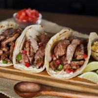 The Steak Taco · Mouth-watering steak taco topped with your choice of beans, cheese and salsa fresca in your ...