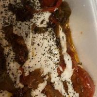 Banjan Borani · A tasty dish of eggplant blended with garlic and onions, topped with a zesty yogurt sauce.