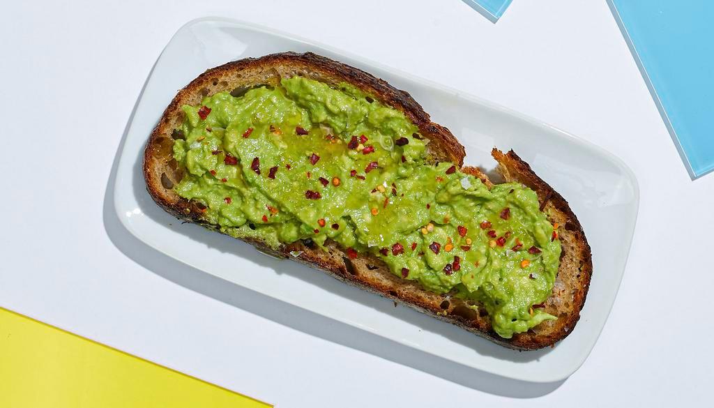 Avocado Toast · Smashed avocado on whole wheat toast topped with red chili flakes, cracked sea salt, and olive oil.