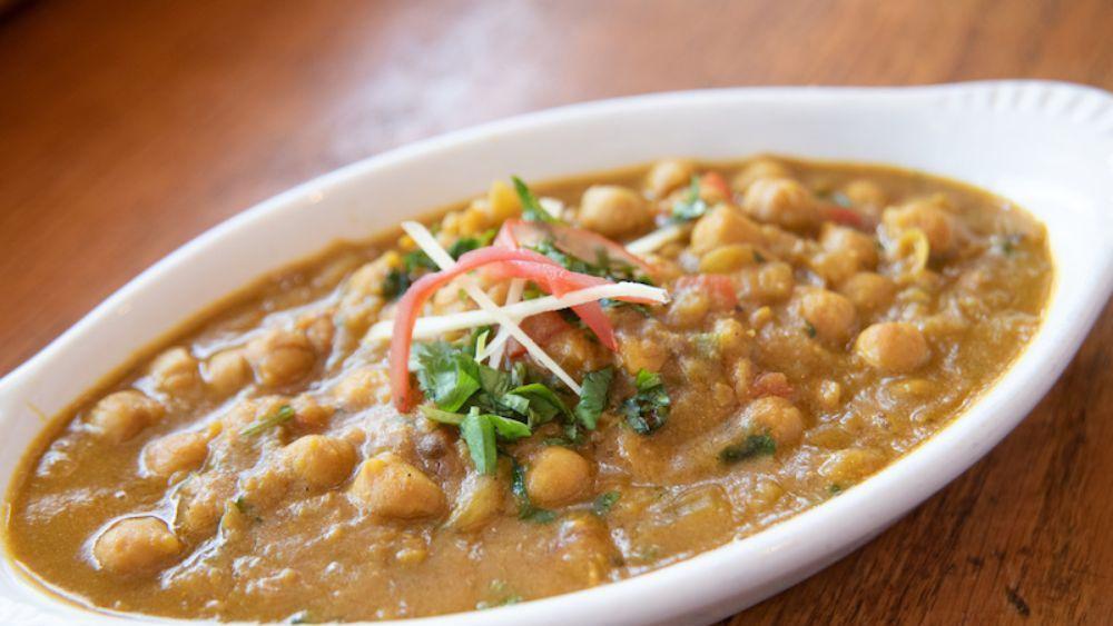 10. Chana Masala · Vegan. Garbanzo beans cooked with fresh tomatoes, ginger, garlic, coriander, bay leaves and spices.