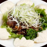 Worcestershire Lamb with Steamed Bun · Sautéed sliced leg of lamb with onions and served with steamed bun.