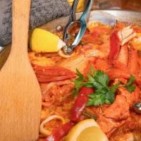Lobster Claw Paella · Saffron bomba rice with a lobster claw in shell, shrimp, calamari rings and clams all made i...