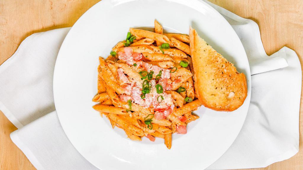Cajun Penne Pasta · A choice of chicken or jumbo shrimp smothered in alfredo sauce with a hint of Cajun spice. Topped with tomatoes, chopped green onions, and parmesan. Served with grilled garlic bread.