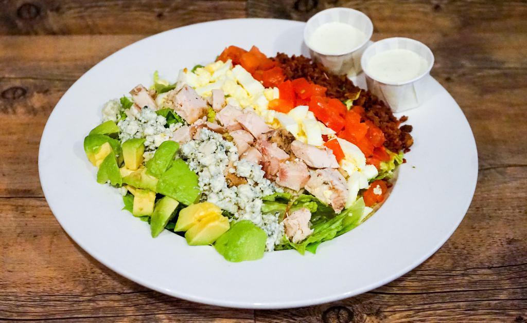 Chicken Cobb Salad · Romaine lettuce topped with chicken breast, applewood smoked bacon, blue cheese crumbles, hard-boiled egg, tomato and avocado.