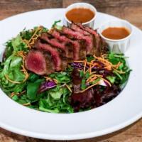 Thai Beef Salad · Mixed greens topped with strips of grilled, marinated Thai beef, carrots, cilantro, red cabb...