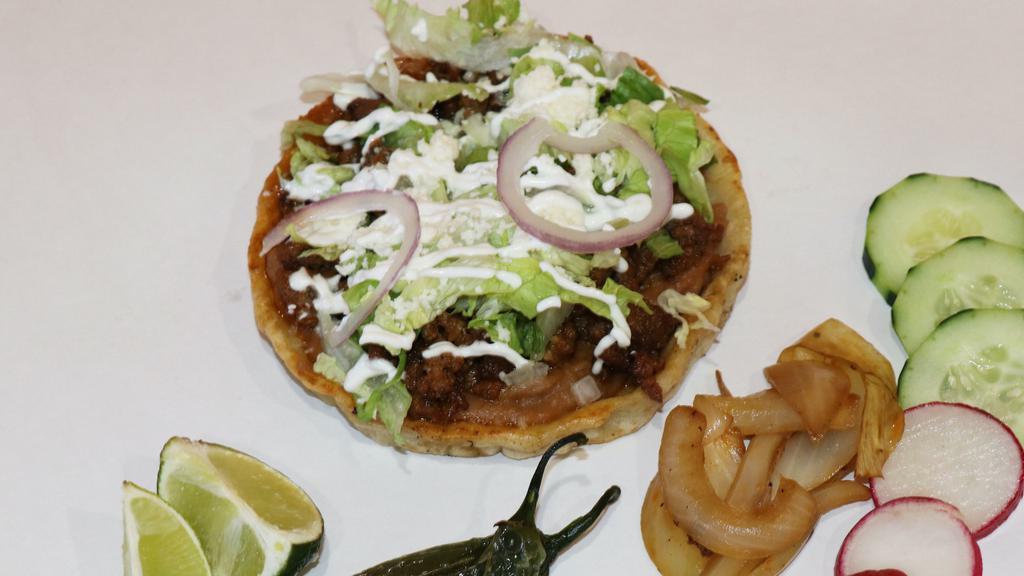Sopes · A sope is a popular street snack. A sope is a handmade corn shell that we like to think of as a little cup; thicker than a tortilla, the sope shell has the added benefit of a rim around the edge to keep in all of the toppings. It comes with refried beans, choice of meat, lettuce, queso fresco, sour cream and salsa.