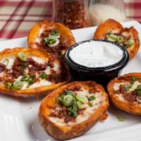 Potato Skins · Topped with melted cheese, chopped bacon, green onions, and sour cream.