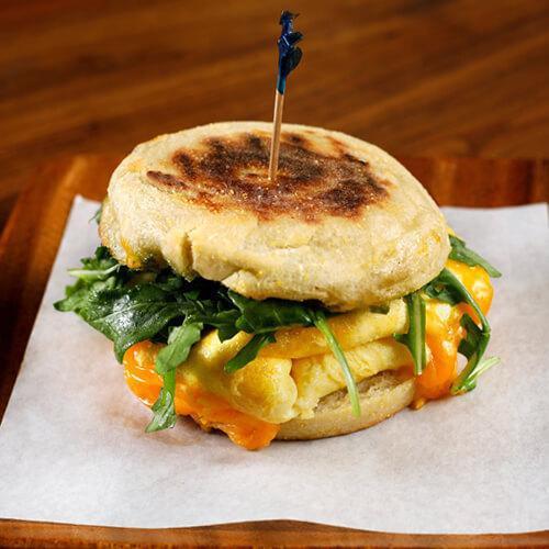Breakfast Sandwich – Egg and Cheese Only · soft scrambled eggs, aged sharp cheddar, wild arugula, our green herb sauce, Wolferman’s english muffin