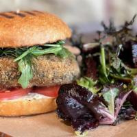 Crisp Oven Fried Portobello Burger · filled with savory herbs, fontina, and chopped mushrooms, with sliced tomato, Dijon-black tr...