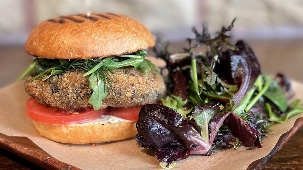 Crisp Oven Fried Portobello Burger · filled with savory herbs, fontina, and chopped mushrooms, with sliced tomato, Dijon-black truffle aioli, and herbed arugula on a toasted Acme bun