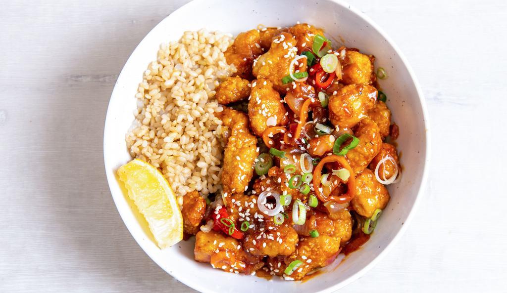 Orange Chicken 2.0 · Antibiotic-free, oven-fried chicken with peppers & onions, green onions, sesame seeds, and our house-made orange sesame sauce. Served with a lemon wedge, and a base of your choice. (gluten-free)