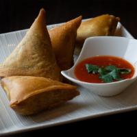 Samosas · Vegan. Hand-made wheat-flour wraps fried and filled with potatoes, onions and spices. Served...