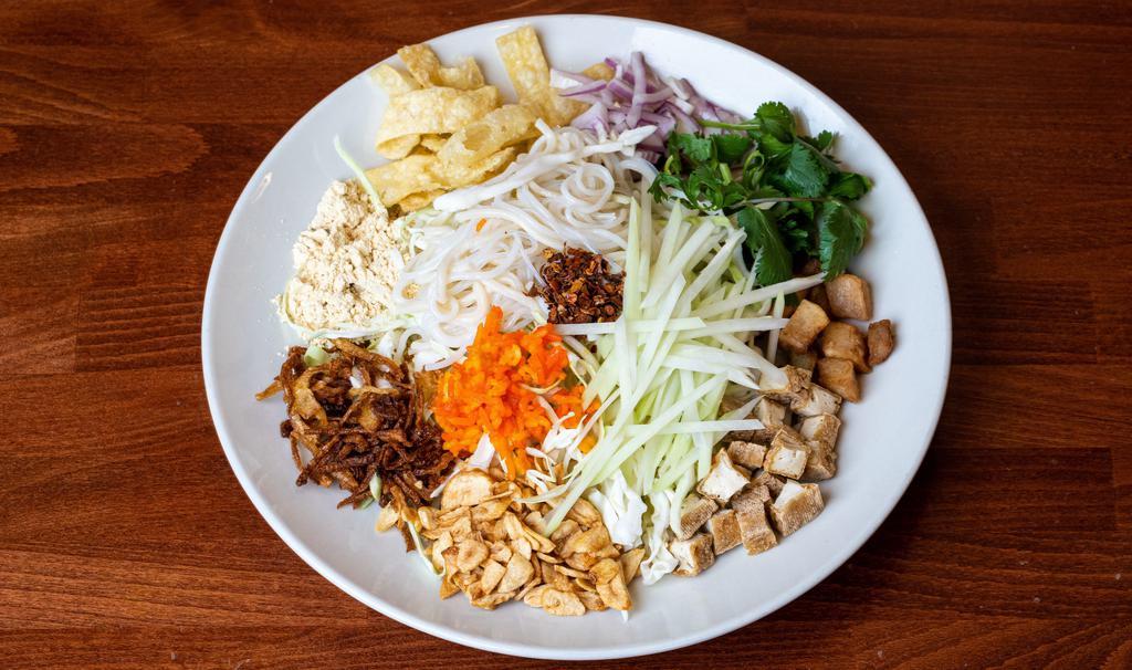 Burmese Rainbow Salad · Gluten-free, Egg noodle, two types of rice noodles, vermicelli noodle, red onions, cucumber, cabbage potatoes, jasmine rice, cilantro, green papaya, jalapeños, tofu, fried onions, fried garlic, fried wontons, yellow bean powder, chili flake, tamarind sauce and onion oil. GFS.