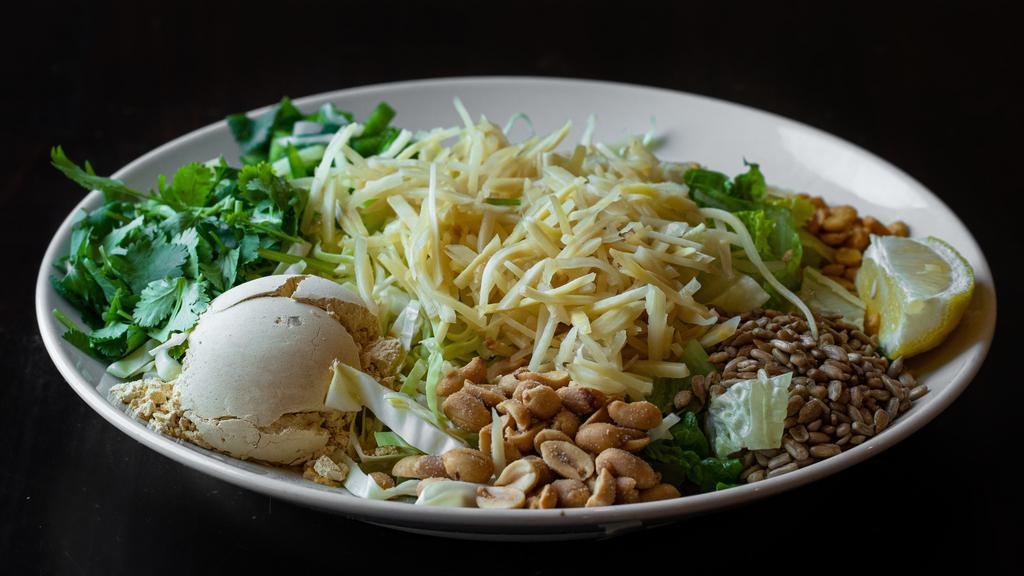 Ginger Salad · Gluten-free, Pickled Ginger, fried garlic, yellow beans, yellow bean powder, peanuts, sesame seeds, sunflower seeds, jalapenos, cilantro, onions, dried shrimp powder on a bed of cabbage. Vegetarian Option Available