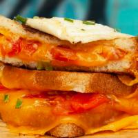 Breakfast Grilled Cheese · Melted cheddar, egg, and tomato between two slices of buttery grilled bread.