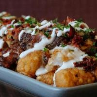 Loaded Tater Tots · Tater Tots, Pulled Pork, Habanero Cheese Sauce, Bacon Bits Pico de Gallo, and Sour Cream.