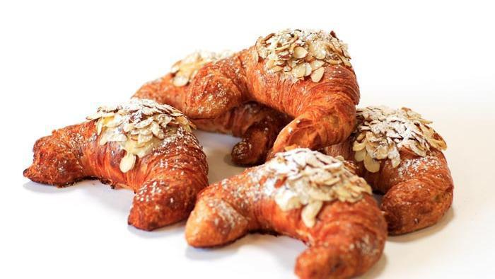 Almond Croissant · Filled with vanilla pastry cream and sprinkled with sliced almond and powder sugar.