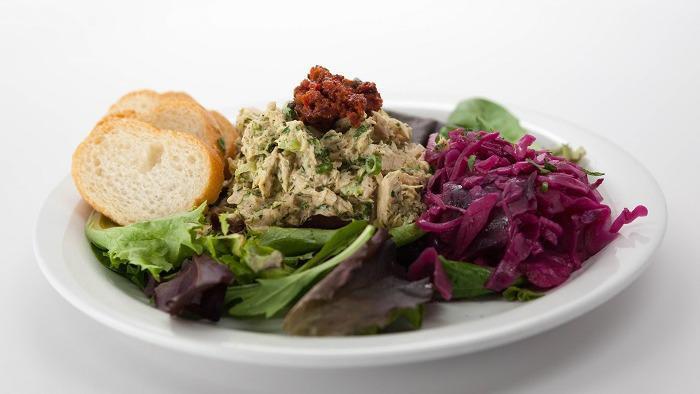 Lemony Herb Tuna Salad · Albacore Tuna mixed with lemon juice, vegan mayo, celery, and fresh herbs on spring mix with sides of potato and cabbage. Topped with an olive tapenade, lemon vinaigrette, and sliced baguette.