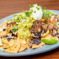 Birria Nachos · Signature birria piled on top of house fried chips with guacamole, pico, jalapeños, and sour...