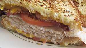 Turkey Melt · Sliced turkey breast with bacon, tomatoes, american cheese and 1000 island dressing. All grilled on sourdough bread.