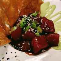 Ahi Poke · Marinated in a soy-ginger sauce, accented with wasabi aioli, served with wonton chips.