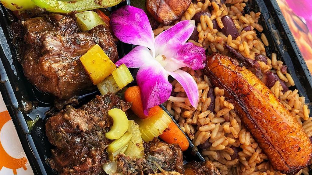 Oxtails With Creole Rice · Oxtails braised with fresh herbs, tomato, baby carrots, bell peppers and onions, served with creole rice( red beans and rice), two deep fried plantain, a side salad, and Chef Ann's signature spicy pineapple dressing.