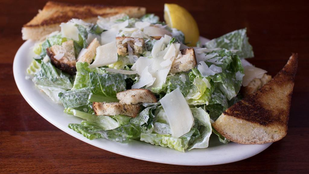 Caesar Salad · Crisp romaine hearts with parmesan and peppercorn-pecorino cheese and garlic croutons tossed in our Caesar dressing.