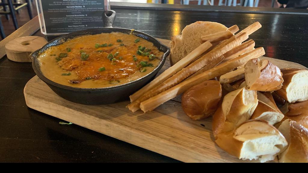 Beer Cheese Fondu · Sharp Cheddar & Gruyere cheese infused with Guinness stout served with toasted Bavarian pretzel bites, toasted crostini, grissini sticks & a whole Bavarian pretzel.