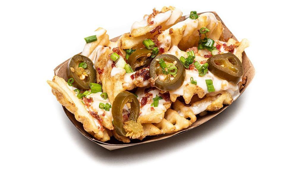 Fried Chicken Nacho Fries · fried chicken bites, queso, bacon, chipotle ranch, pickled jalapeno, green onion