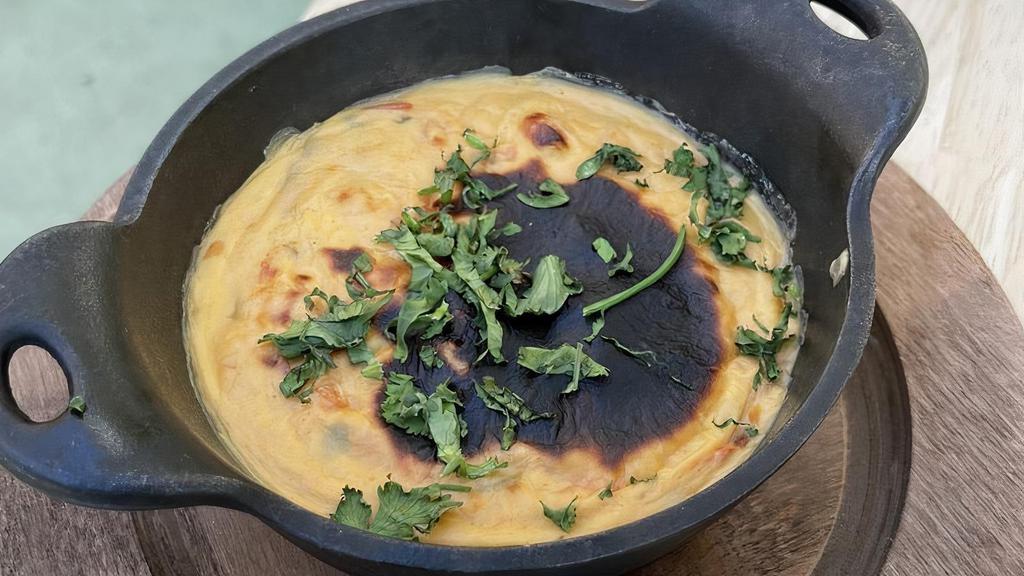 Queso Fundido · Oaxaca, gouda and Monterey cheese blend, peppers, tomatoes, spices.