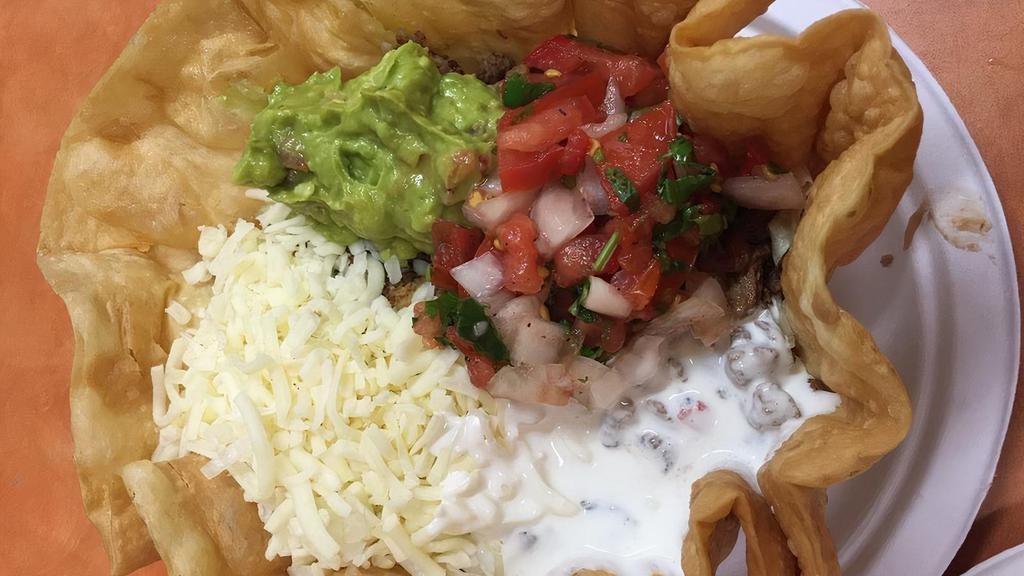 Taco Salad · Flour Tortilla bowl filled with choice of meat, rice, beans, lettuce, Monterey cheese, sour cream, guacamole, pico de gallo, and salsa.
