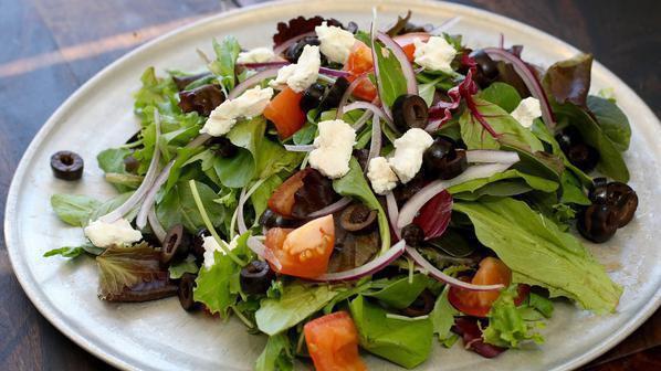 House Salad · Mixed organic greens, tomatoes, olives, goat cheese, and sliced onions with a lemon olive oil dressing.
