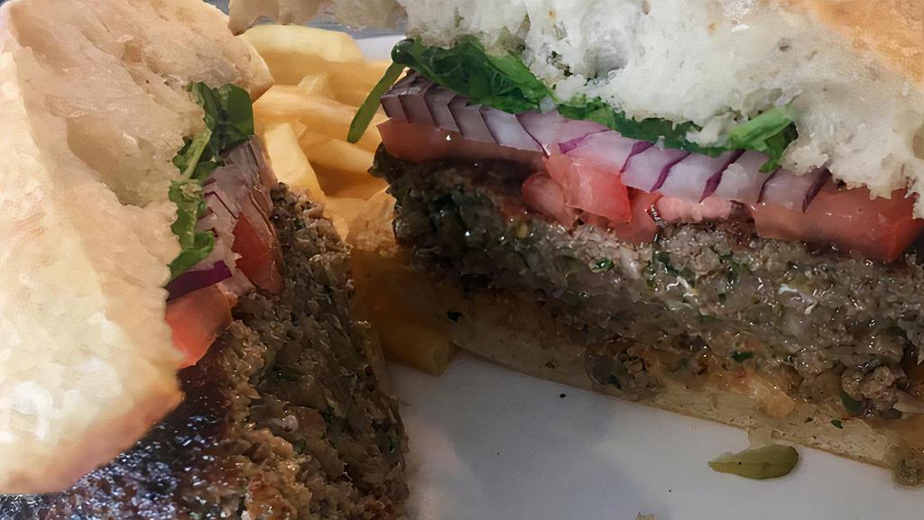 Lamb Burger (Kufta) · Grilled grass-fed beef and lamb seasoned with Mediterranean spices topped with arugula, tomatoes, red-onions and Tamra house sauce, on a ciabatta bun.