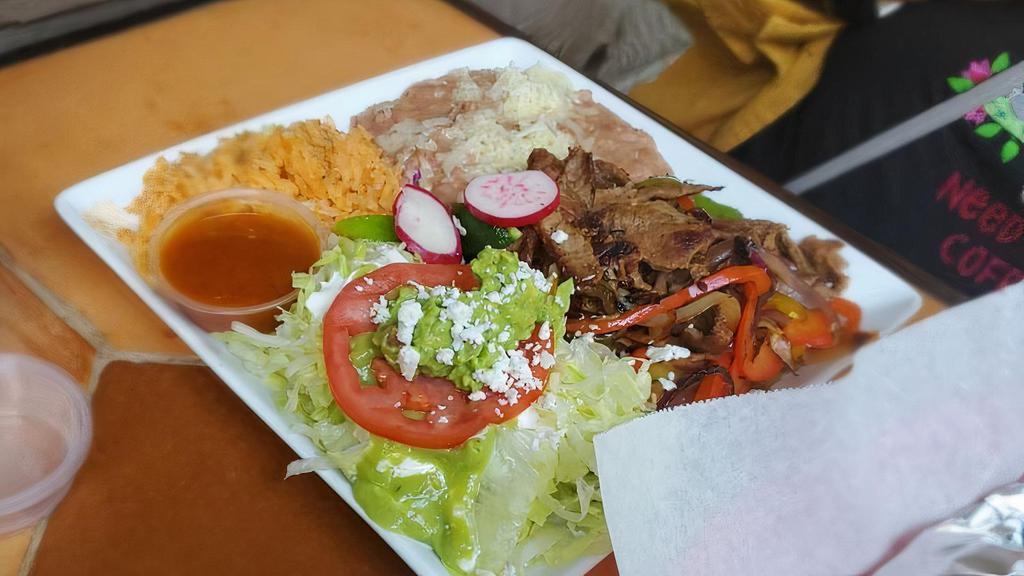 Fajitas · Choice of grilled beef or chicken, grilled onions, bell peppers, rice, beans, guacamole, sour cream, salad, and tortillas.