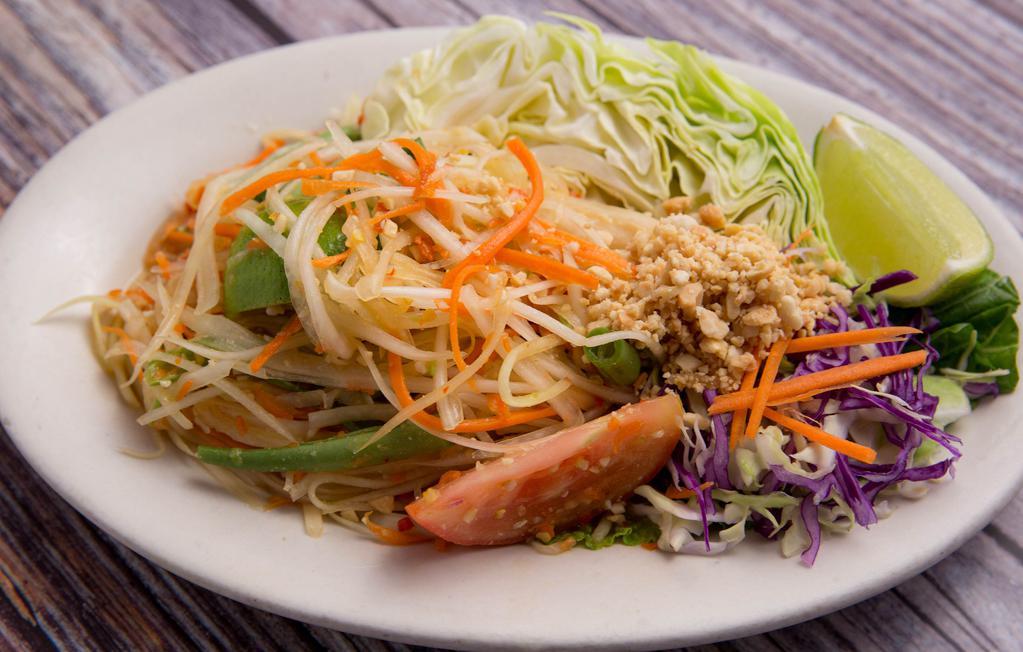 Papaya Salad · Shredded green papaya with tomato, green bean, ground peanut, and dry shrimp in spicy lime dressing served with sliced cabbage.