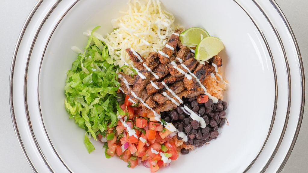 Grilled Marinated Steak Pasilla Bowl · Pinto or black beans, Spanish rice, fresh homemade salsa, cheese, sour cream, and lettuce.