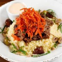 Lamb Tagine Bowl · Served over preserved lemon couscous with a carrot and dried fig slaw, topped with toasted a...