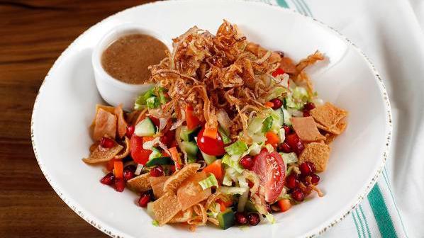 Lentil Protein Bowl · Romaine & cabbage, tossed with radishes, tomatoes, carrots, cucumbers, fresh pomegranate seeds, mint, with pita chips and fried shallots served with lentils & bulgar