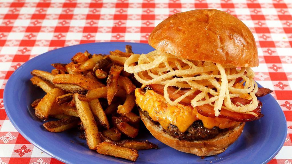 The Maxi Burger · We grind our own blend of chuck and beef brisket, topped with pimento cheese, crispy onion strings, and Minnie's own bacon.